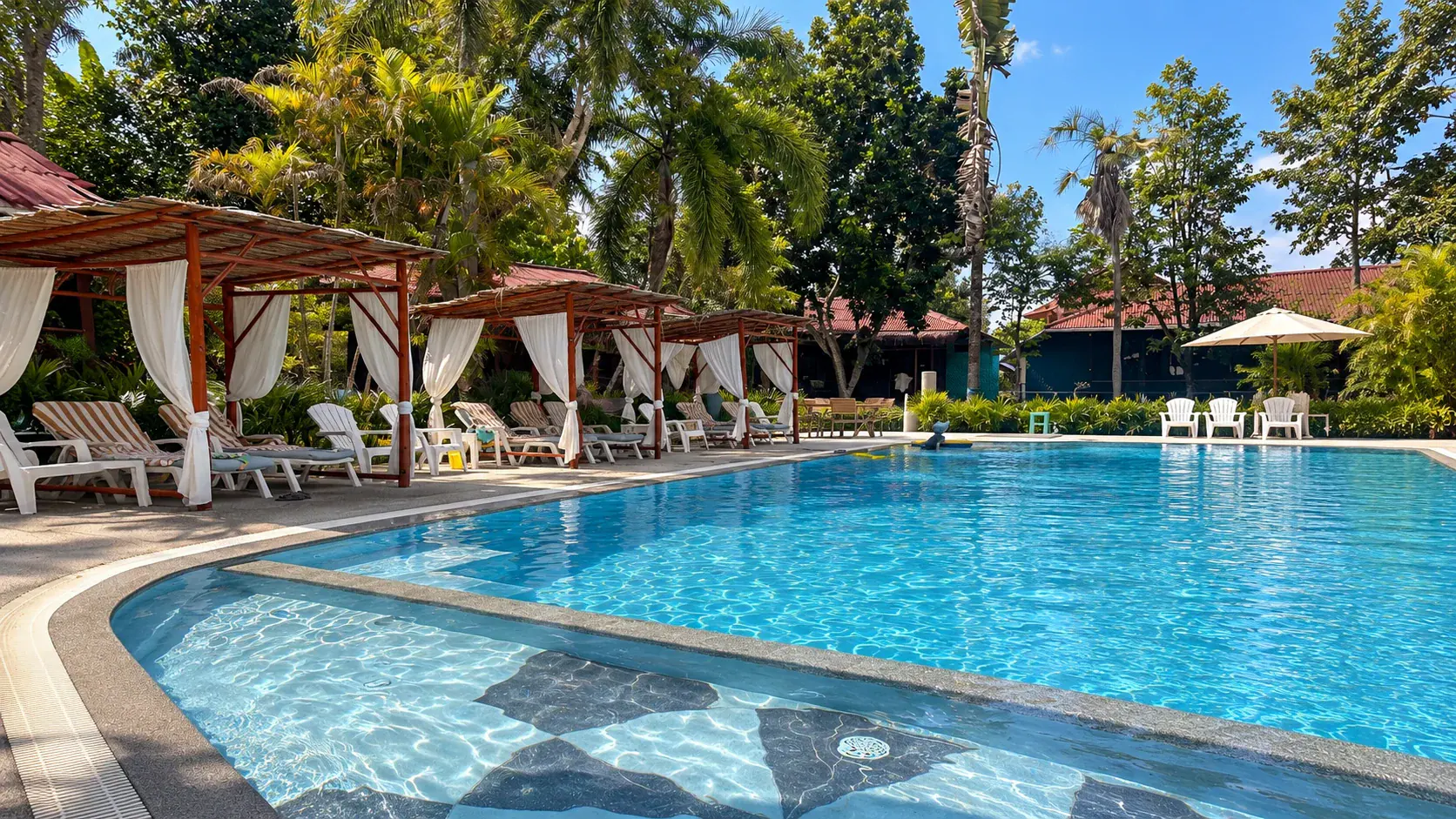 Pool at Baan Kiao Resort in Haad Yao, Koh Phangan, with white salas and the tropical garden