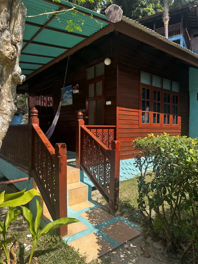 A wooden bungalow with a carved railing at Baan Kiao Resort, Haad Yao