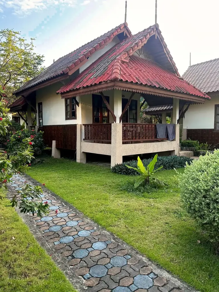 Ein Bungalow mit Veranda und Gartenweg im Long Bay Resort