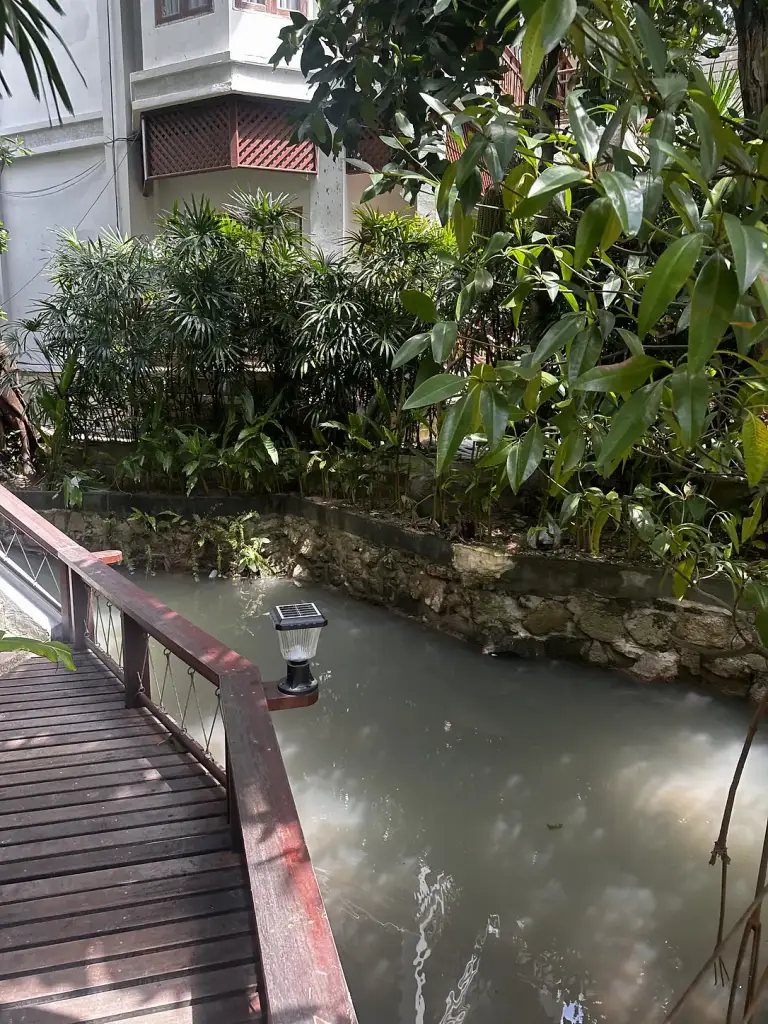 Un pont en bois au-dessus d'un étang entre les bâtiments du Ban's Diving Resort