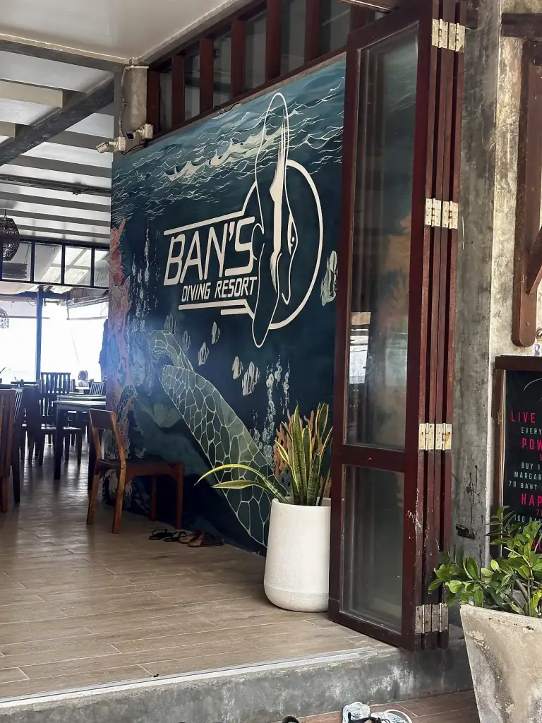 Le restaurant de plage du Ban's Diving Resort avec sa grande fresque du logo, Sairee