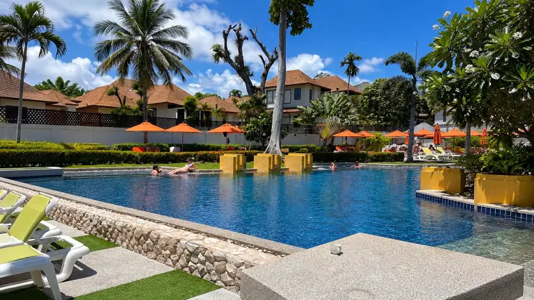 Piscine du Beyond Samui avec des jardinières jaunes et des parasols orange, Koh Samui