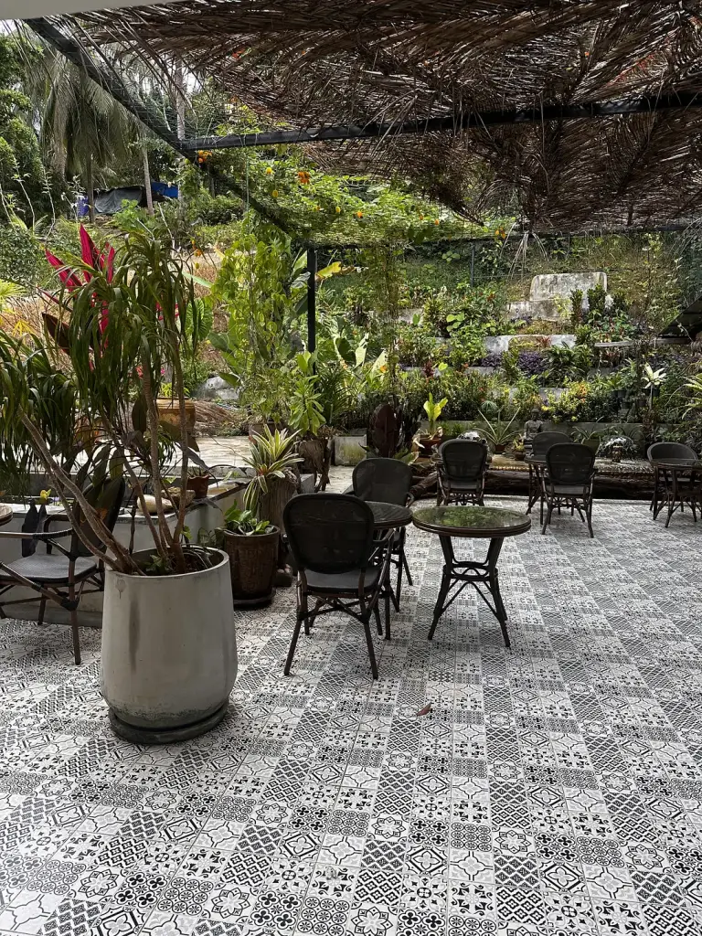 החצר האחורית של Bubba's Roastery, אריחים מצוירים, עציצים ושולחנות קטנים