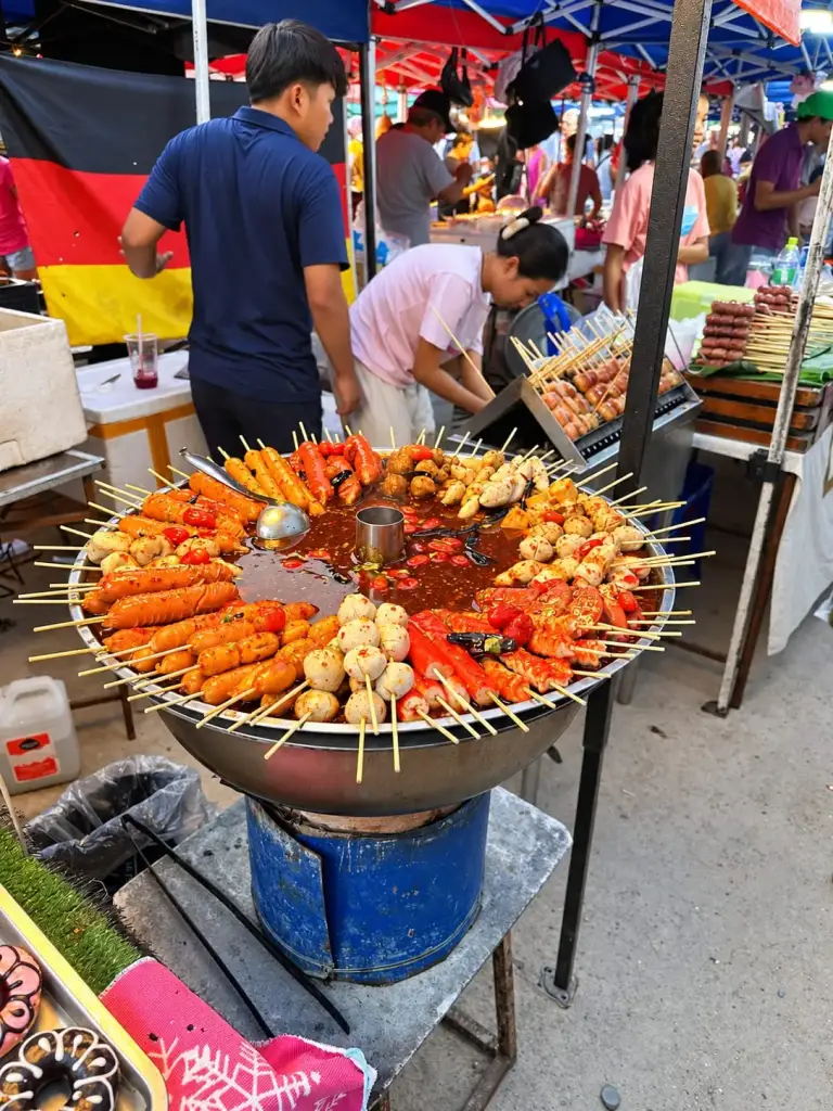 Skewers in a bubbling pot at the Chaloklum Sunday market
