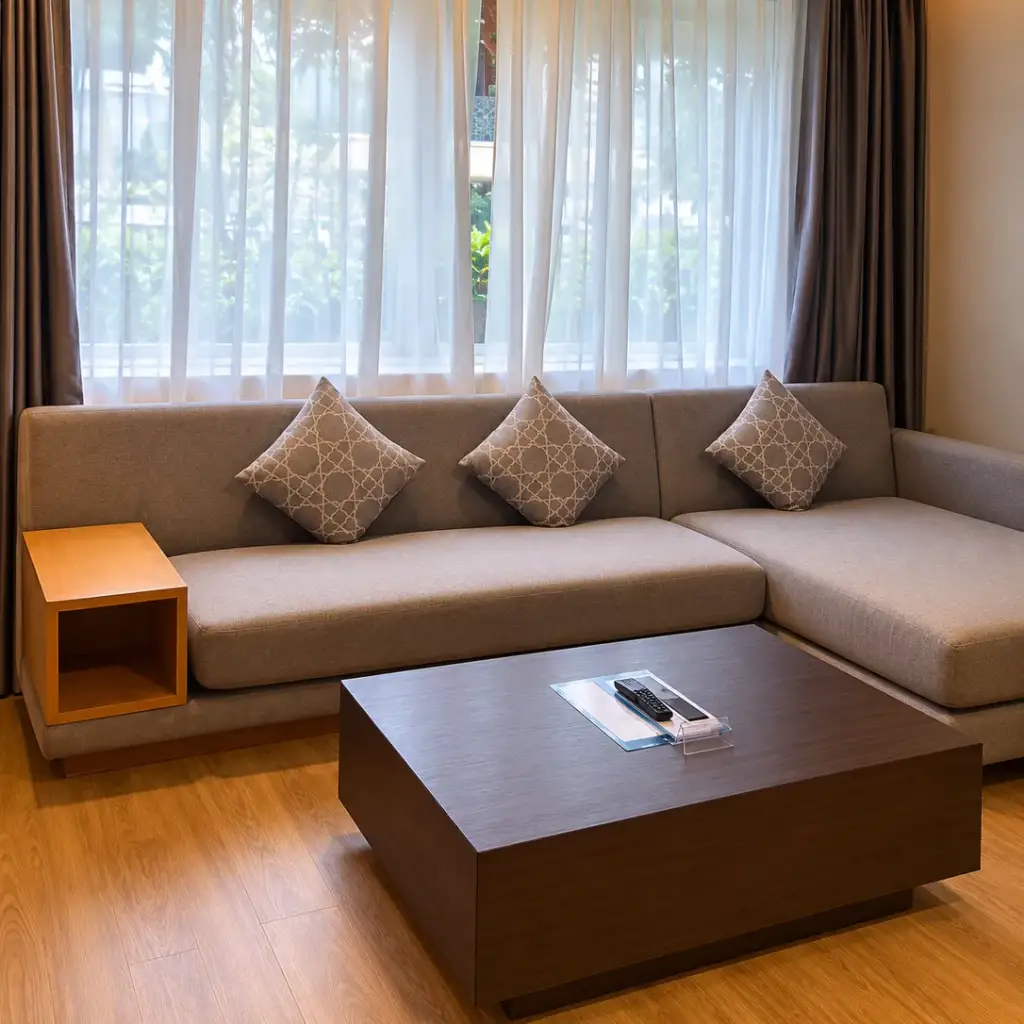 A lounge area with a large sofa and coffee table in a room at Phuket Graceland