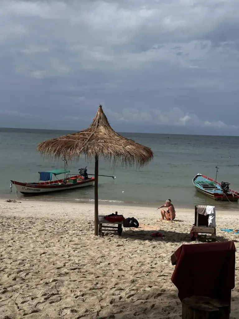 Longtail boats and a thatched parasol at Bottle Beach, Koh Phangan