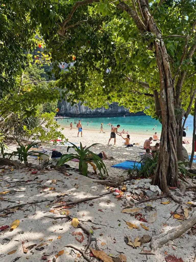 The beach on Koh Hong seen through the trees, with visitors on the sand