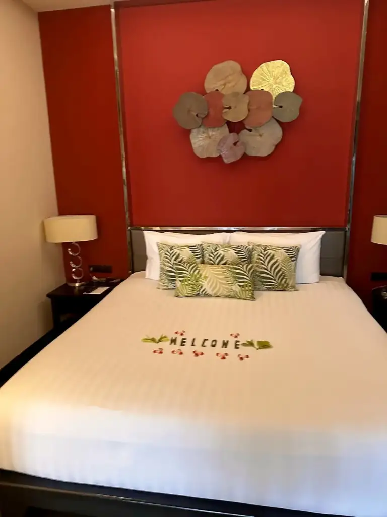 The bed with a Welcome message in the room at Impiana Resort