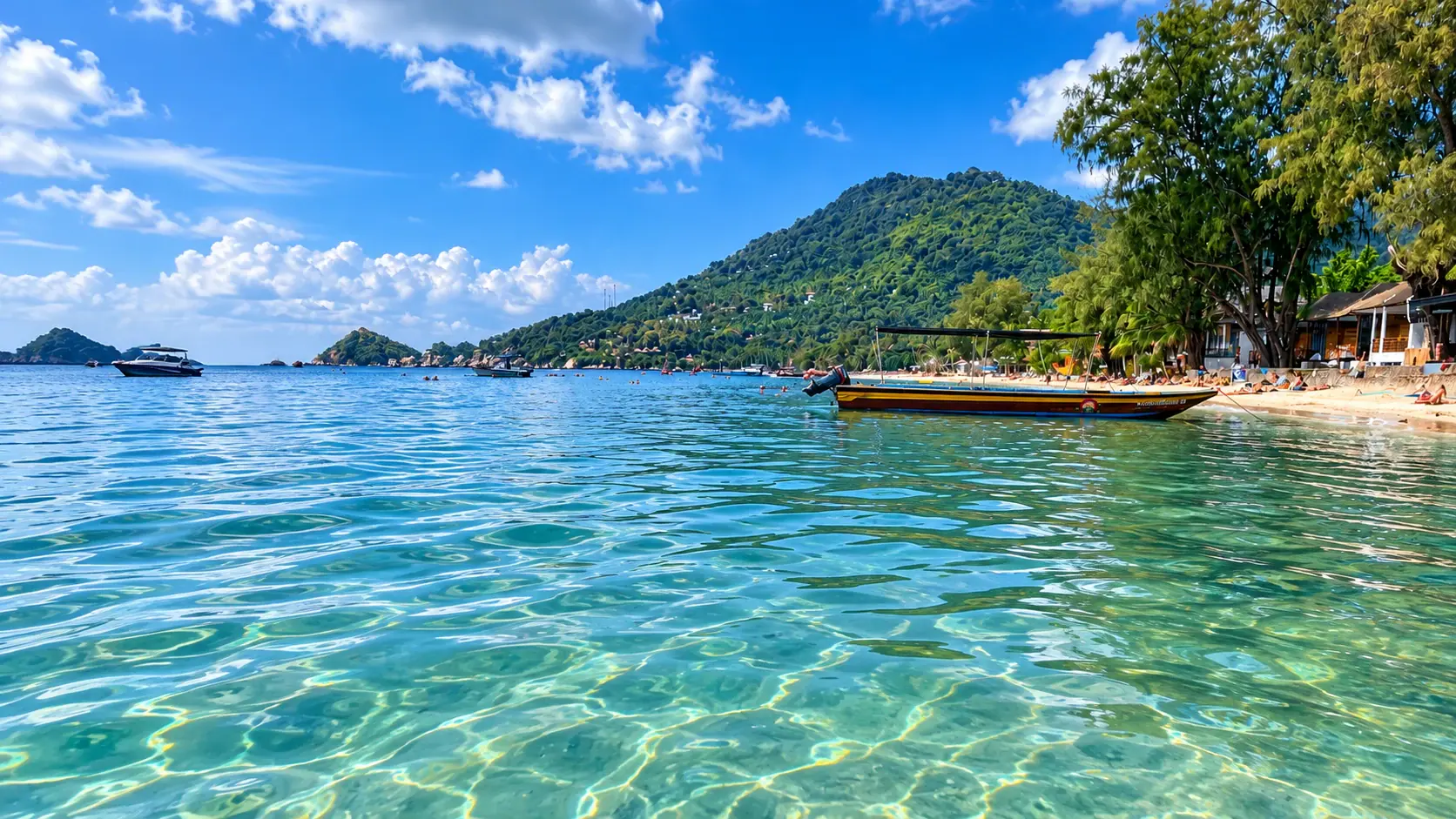 A bay on Koh Tao: clear water, a longtail boat, the beach and a green hill