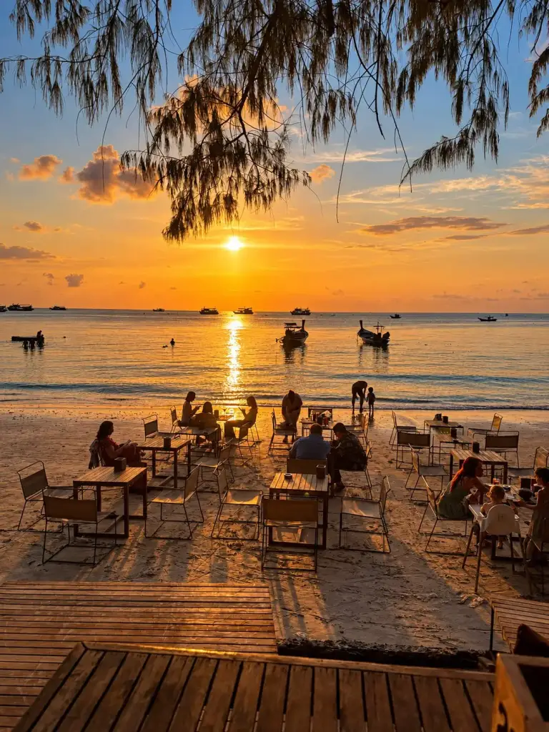 Restaurant tables on the sand facing the sunset at Sairee Beach, Koh Tao