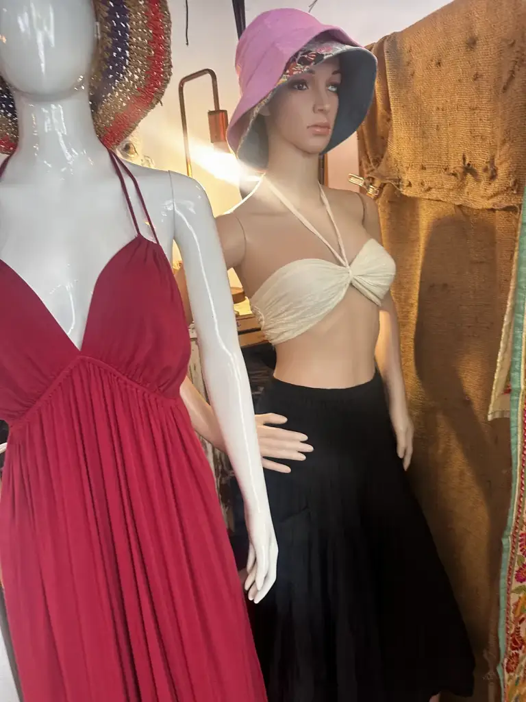 A long burgundy dress and a black skirt on mannequins in Sairee