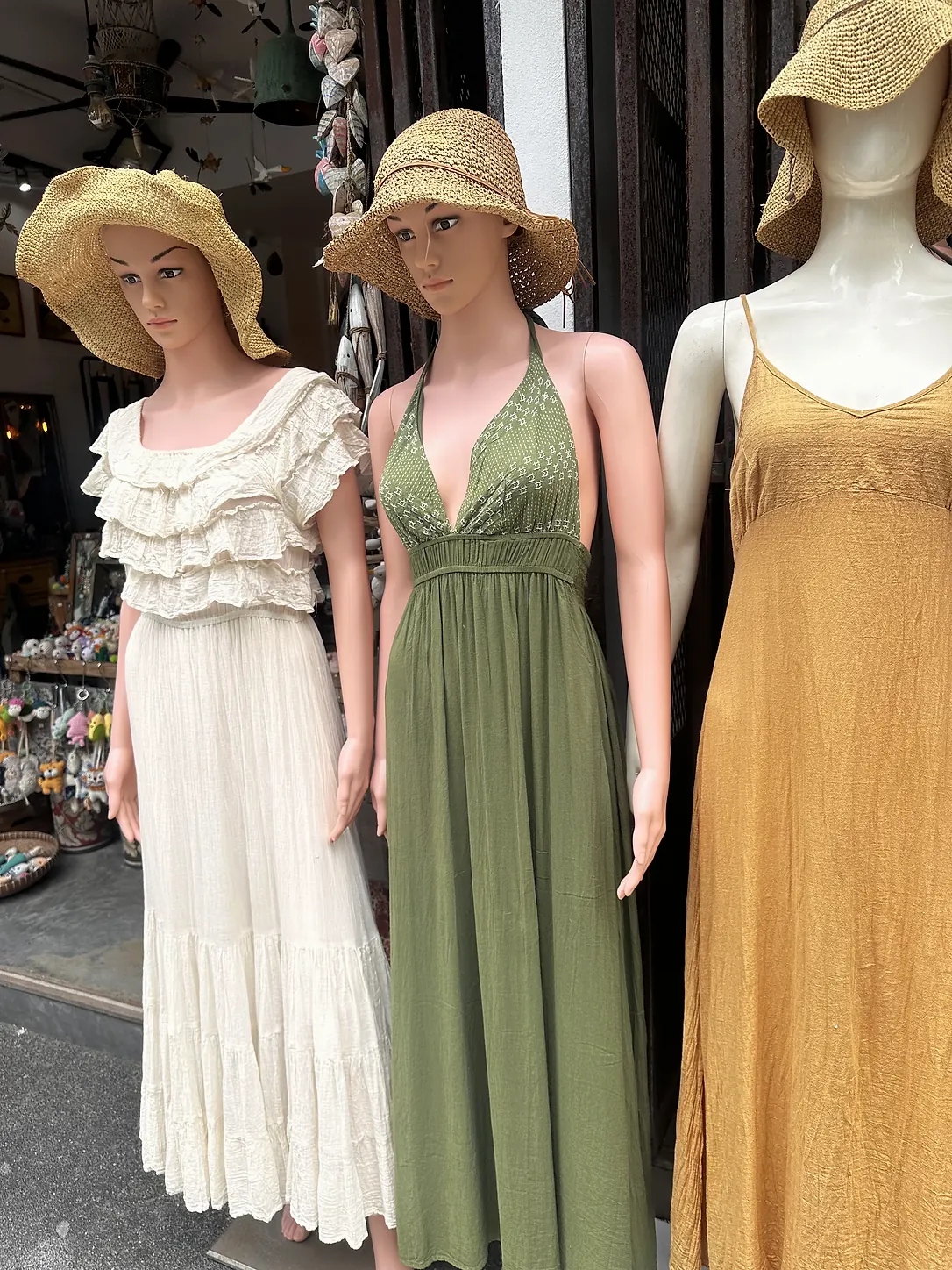 Dresses in cream, olive green and mustard on mannequins in a shop in Sairee, Koh Tao