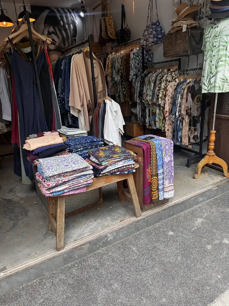 A simple clothes shop in Sairee with piles of trousers and tops
