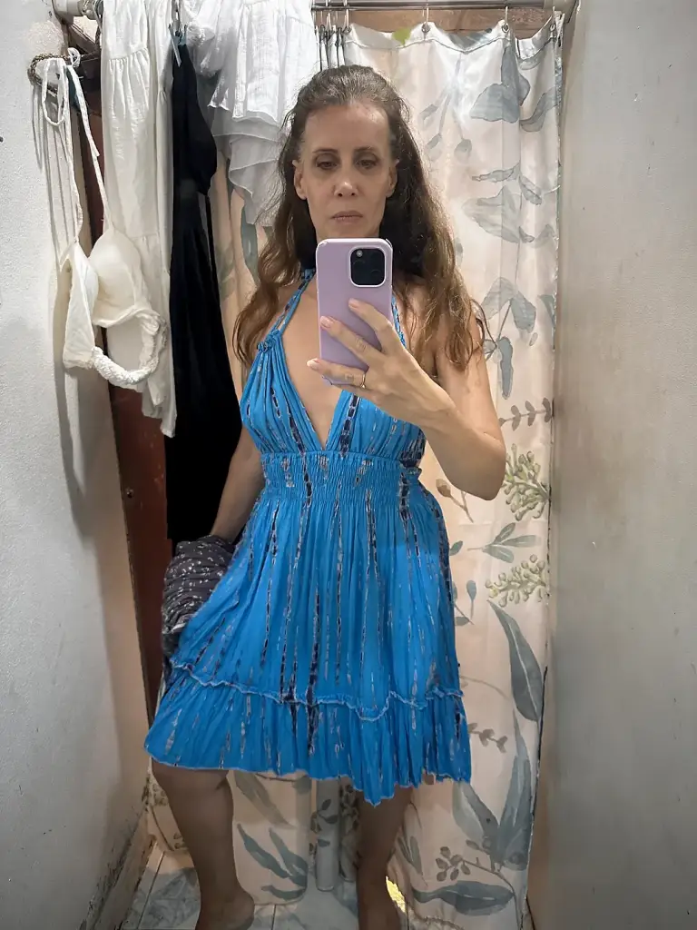 Michelle Loren trying on a blue beach dress in a fitting room in Sairee