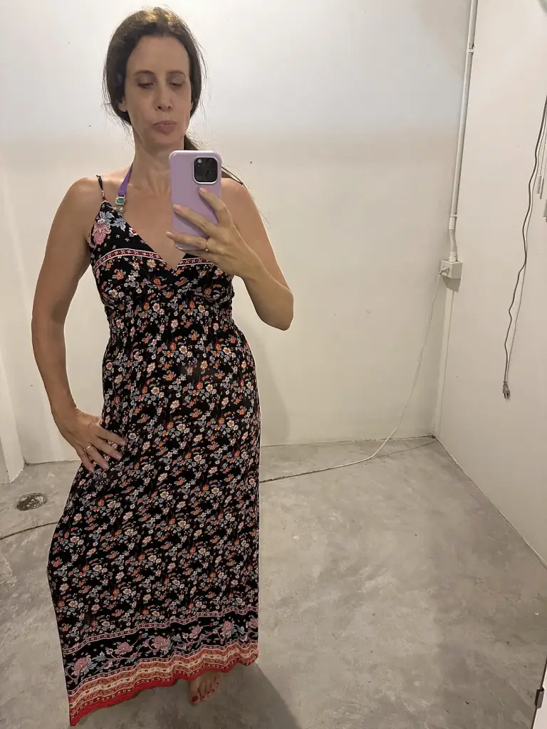 Michelle Loren trying on a long floral dress in a shop in Sairee