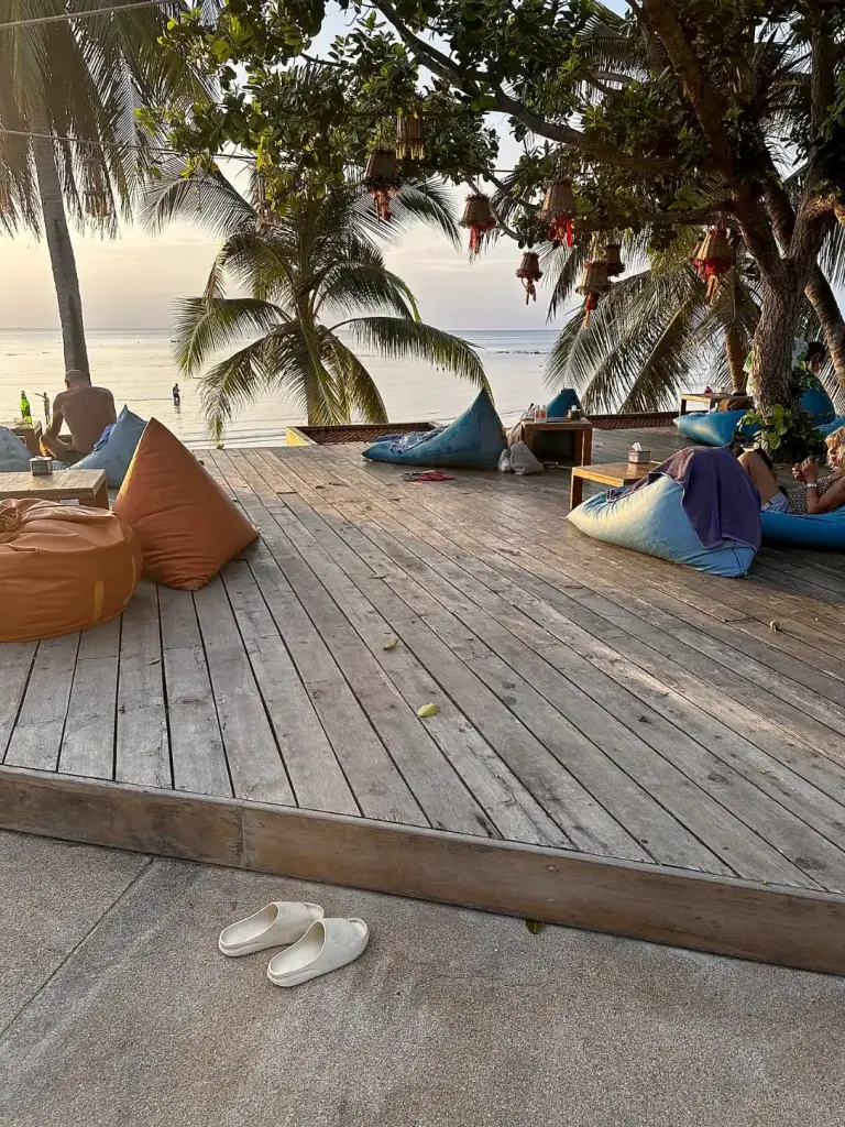 Ein Holzdeck und Sitzsäcke mit Blick aufs Meer im Long Bay Resort, Haad Yao
