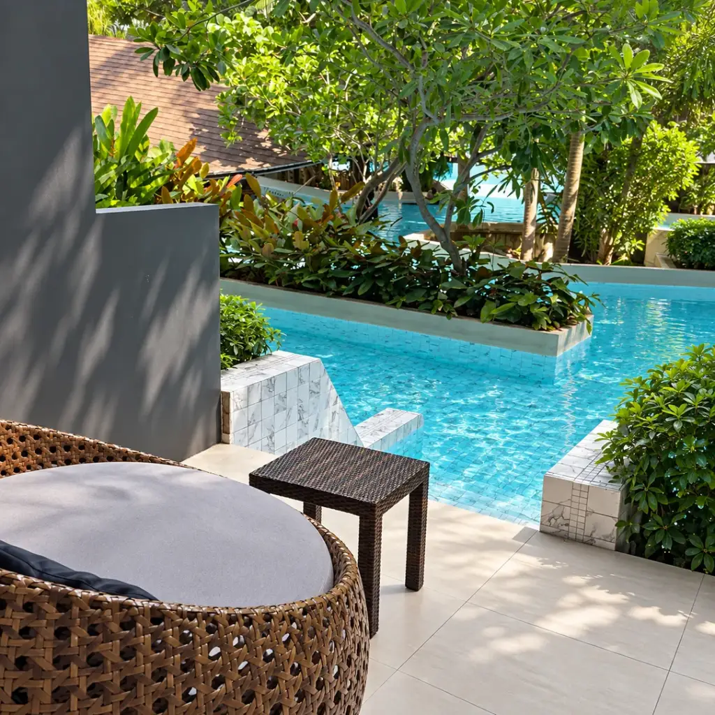 A balcony with a rattan armchair and direct access to the pool at Panan Krabi Resort