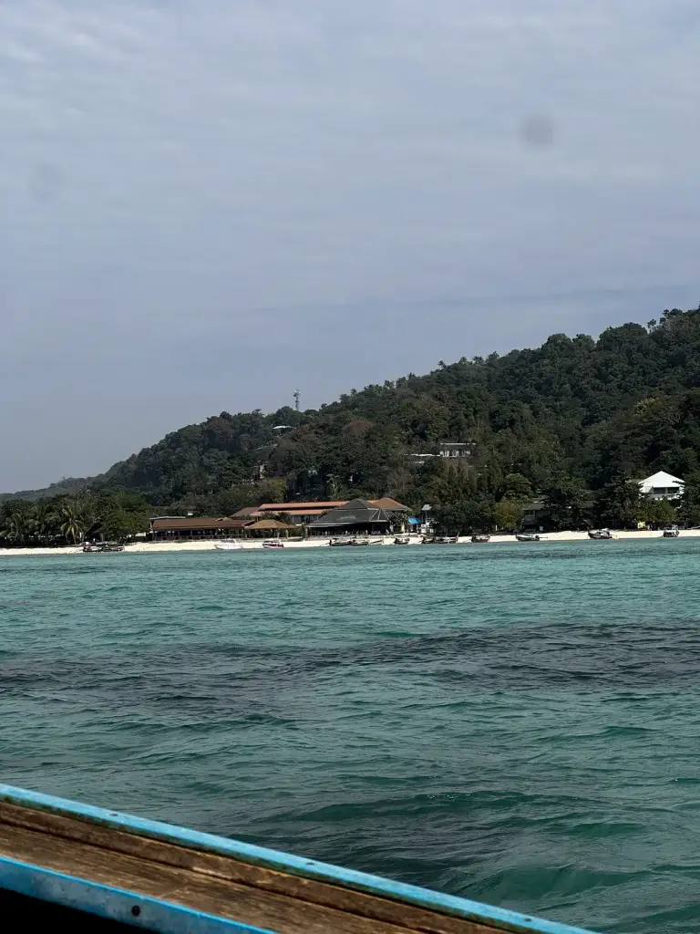 Hotels am grünen Hang über den Buchten auf Koh Phi Phi, fotografiert vom Meer aus