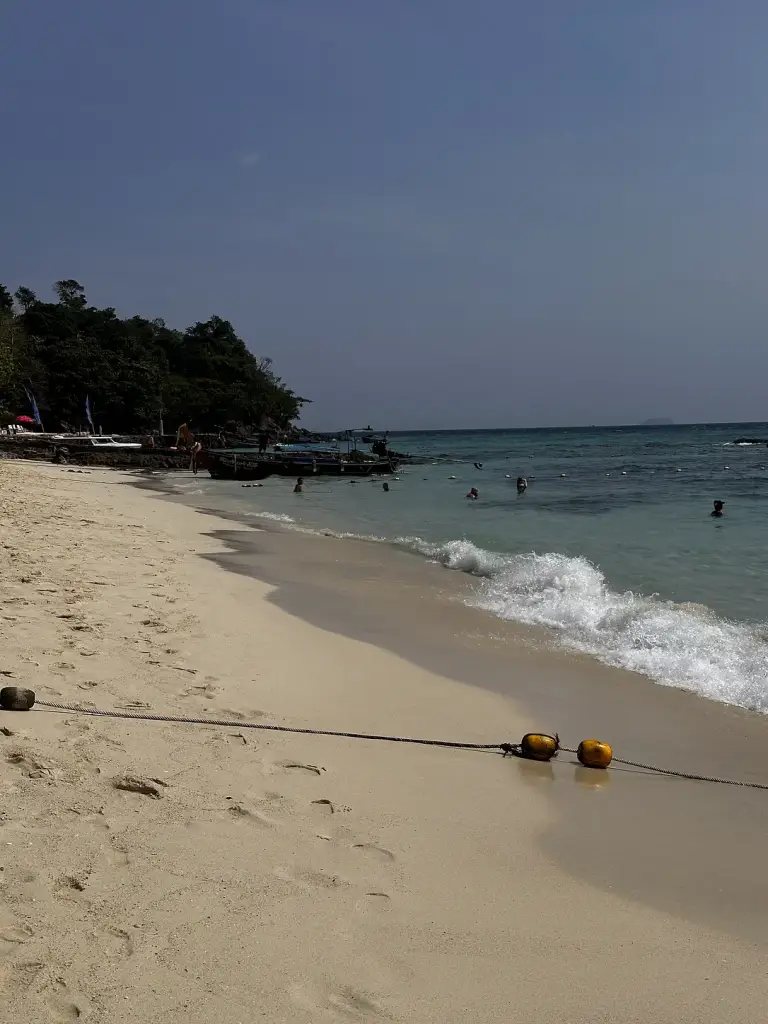 Die Wasserlinie am Long Beach, Koh Phi Phi, und Longtailboote in der Bucht