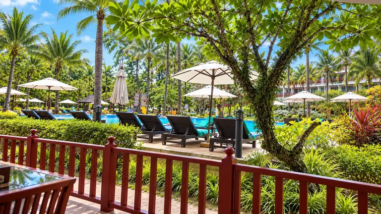 Pool among palm trees at Phuket Graceland Resort & Spa, seen from the balcony, Phuket