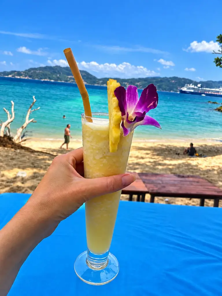 Pineapple shake with an orchid on a sunbed facing the sea at Paradise Beach