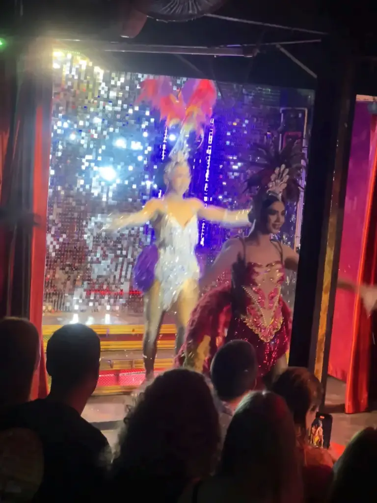 Twee artiesten die dansen voor de glitterwand, Queen's Cabaret Koh Tao
