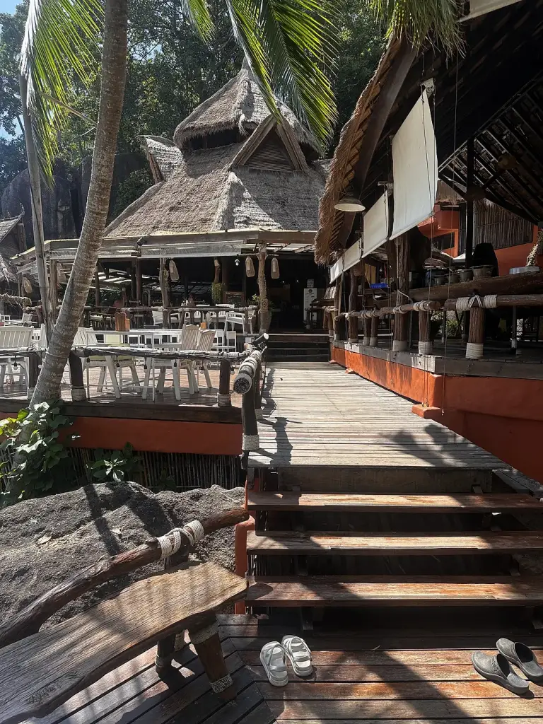 Een paviljoen met rieten dak en een houten looppad bij Rim Lae, Koh Tao