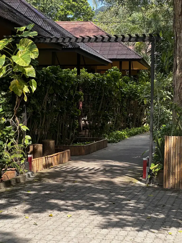 A shaded path between the buildings at Sairee Cottage Resort