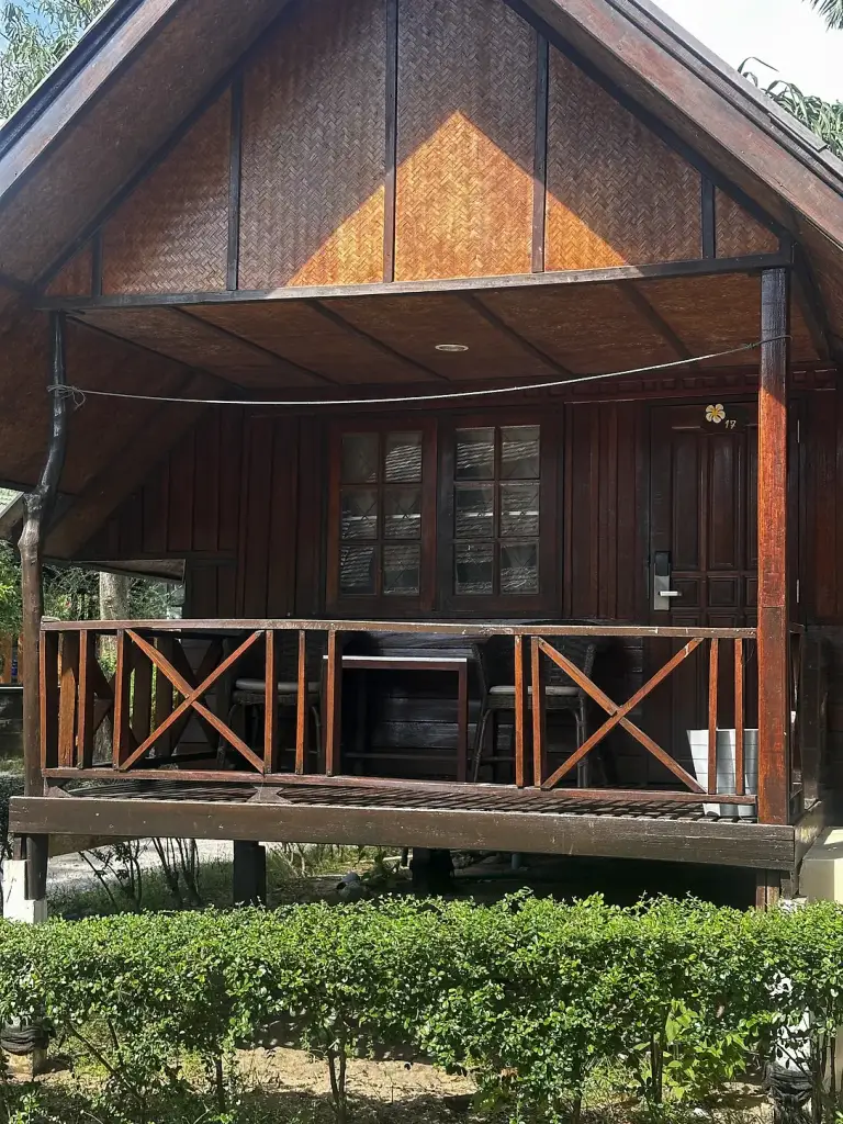 A wooden bungalow with a veranda at Seashell Resort