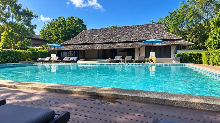 Pool at Seashell Resort in Sairee, Koh Tao, with the tiled-roof wooden building behind it