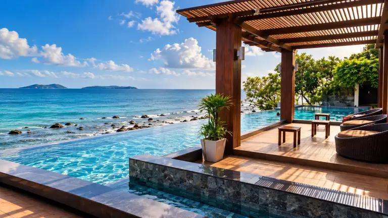 Infinity pool at The Sarann facing the sea and rocks, with a wooden pergola, Koh Samui