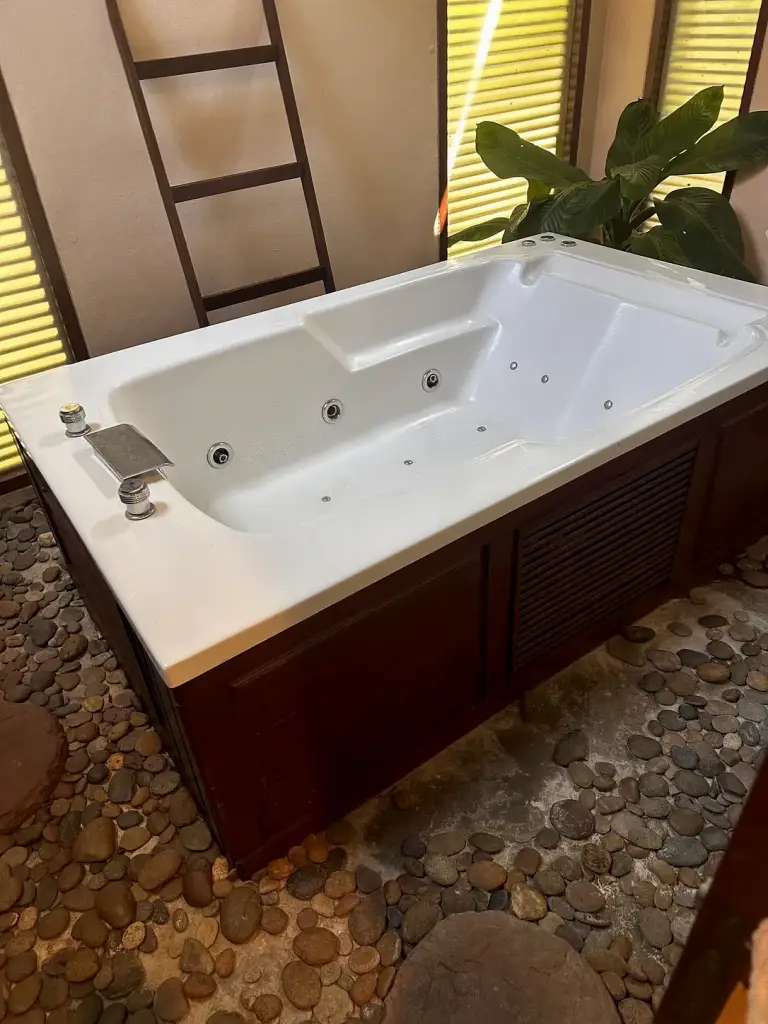 Der Jacuzzi auf einem Boden aus Flusskieseln im The Sarann