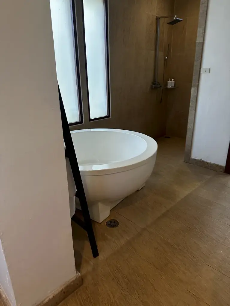 Das Bad der Villa im The Sarann mit freistehender Badewanne am Fenster