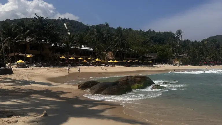 Thong Nai Pan Noi beach: golden sand, large boulders in the water, palms and blue sky, Koh Phangan