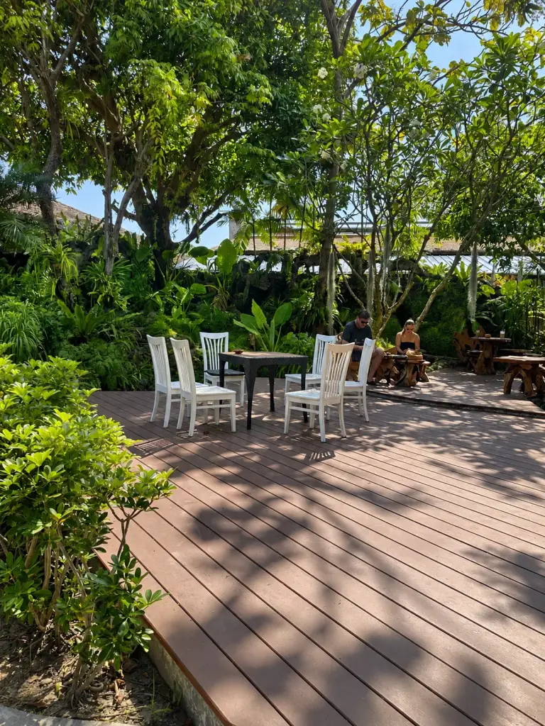 Une terrasse en bois et un coin salon parmi les arbres au Panviman Resort