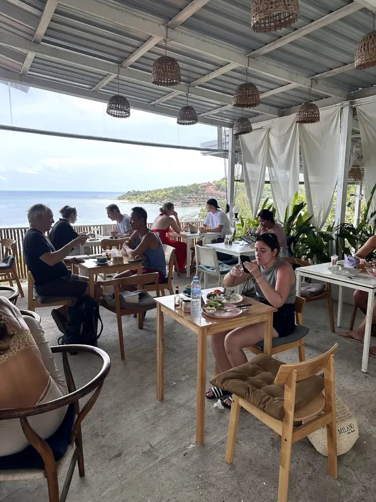 Les tables près de la rambarde chez What's Cup, face à la vue sur Haad Yao